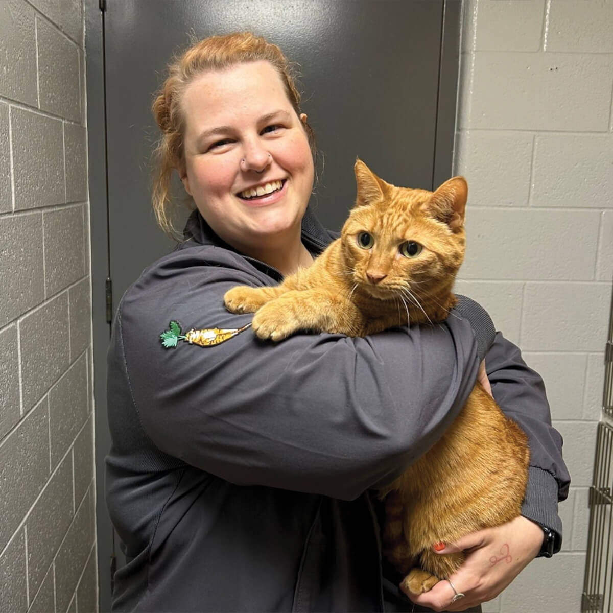 Female Tech Holding Orange Cat